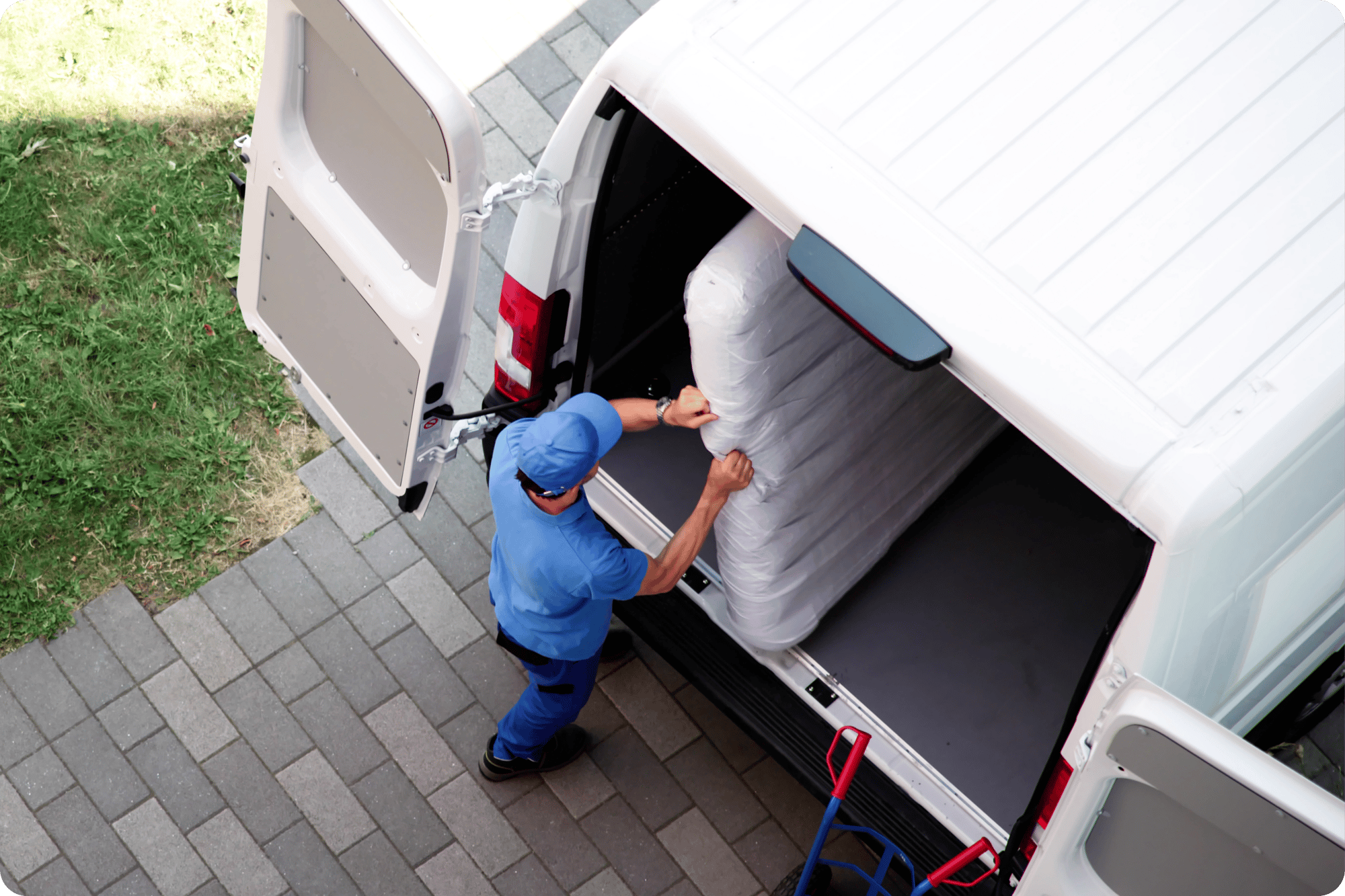 Delivery pro loads a mattress in cargo van.